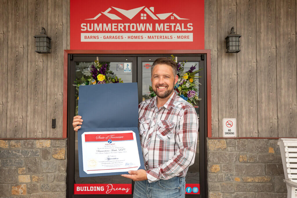matt stoll holding certificate from state of tennessee for receiving the inclusive employer award outside of summertown metals
