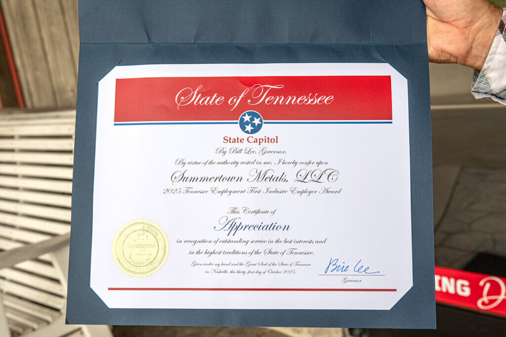 matt stoll holding close up of certificate from state of tennessee for receiving the inclusive employer award
